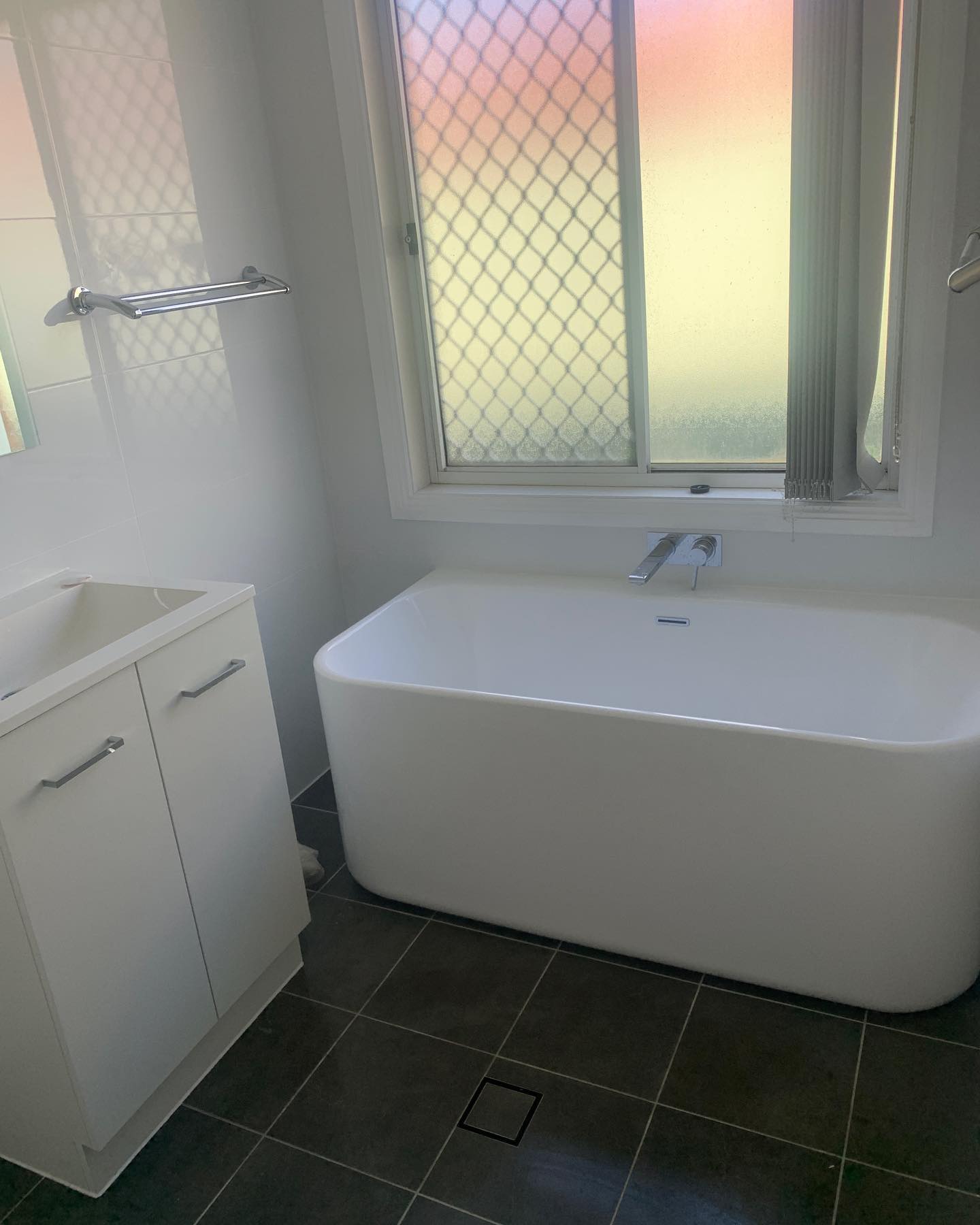 Bathroom after — freestanding bath and new tiling