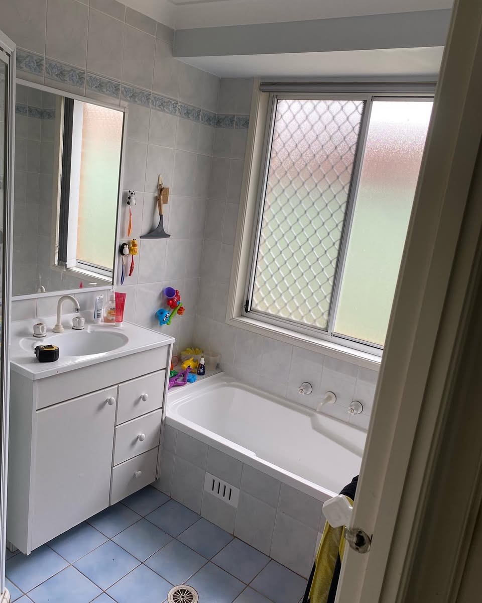 Bathroom before — old blue tiles and bath
