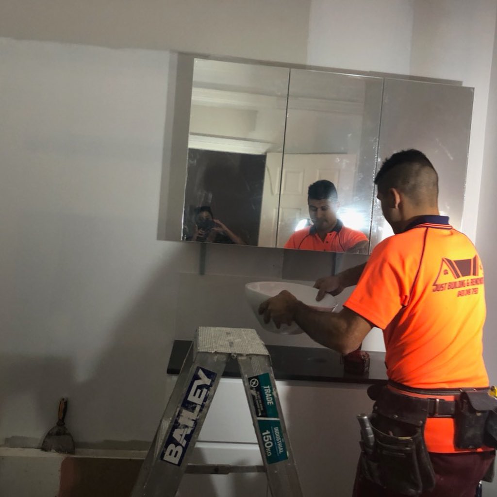 Justin installing bathroom mirror